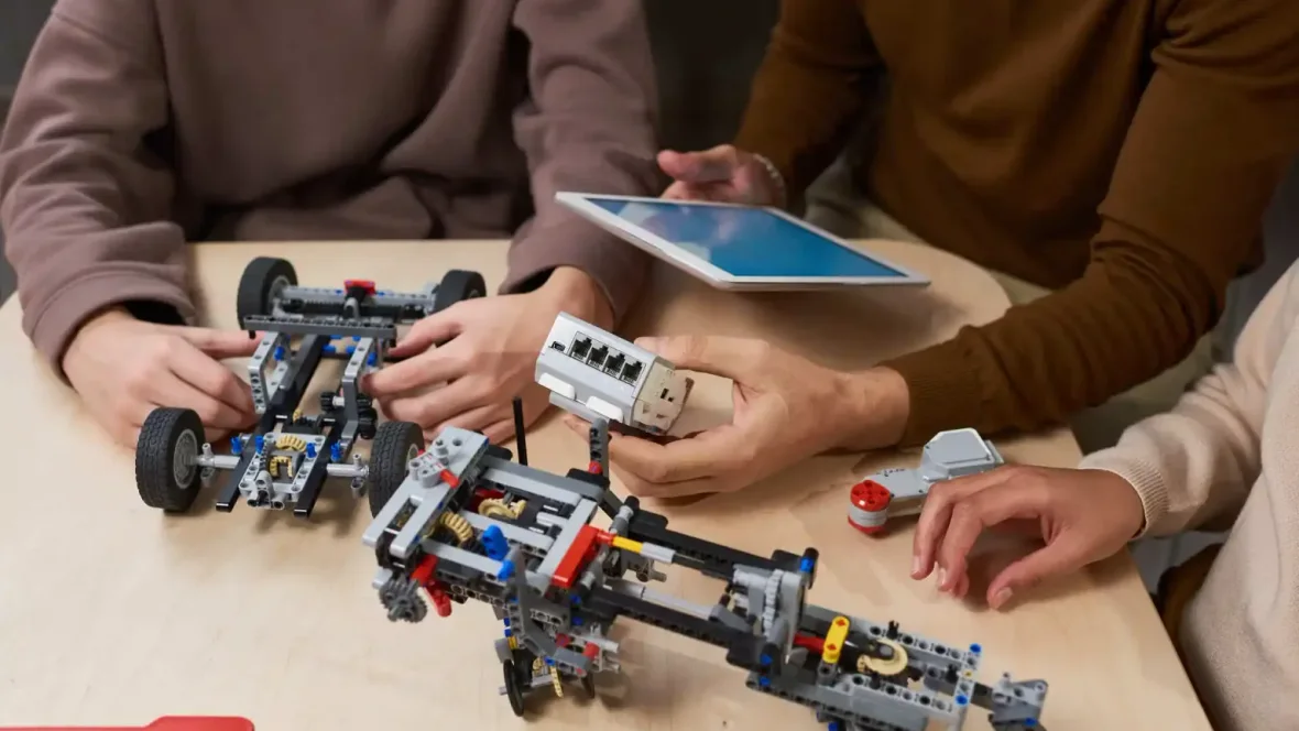 Uczestnicy wspólnie budują roboty, korzystając z tabletu jako narzędzia do projektu