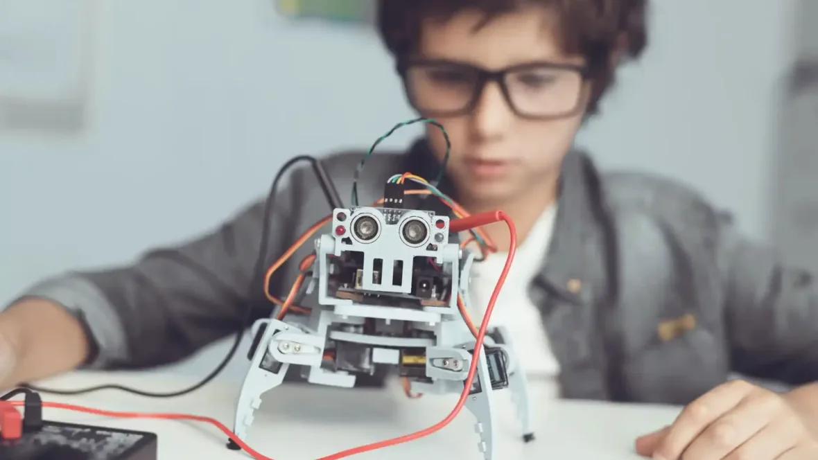 Dziecko testuje samodzielnie zbudowanego robota podczas zajęć